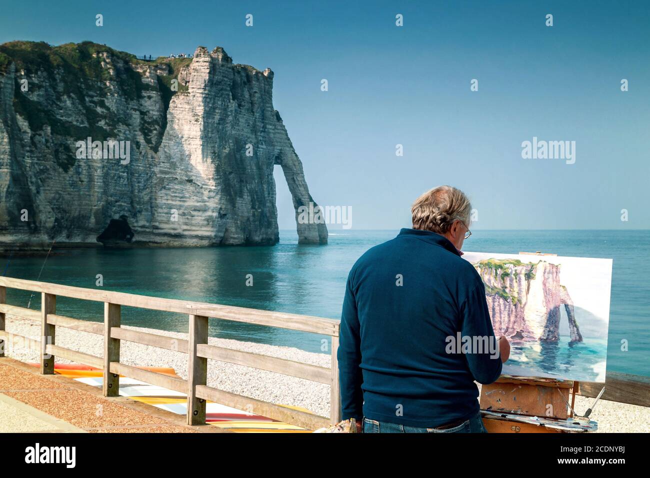 Painter paints the white cliffs of Ètretat with the famous Natural Arch La Porte d`Aval Stock Photo